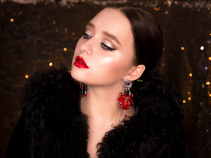 Ideias de maquiagem para madrinha de casamento. Foto mulher branca maquiada com sombra prata e batom vermelho.