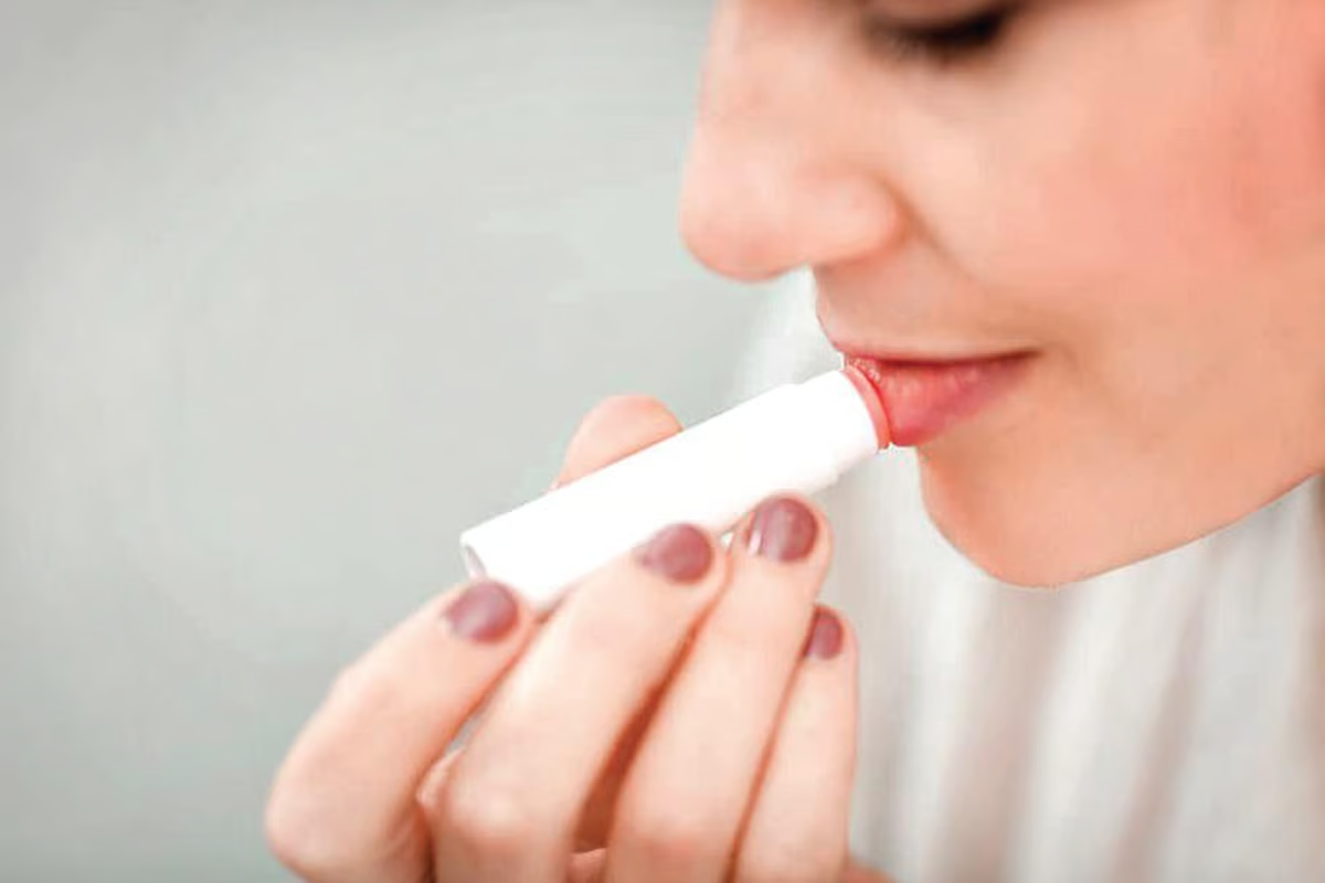 mulher passando hidratando labial