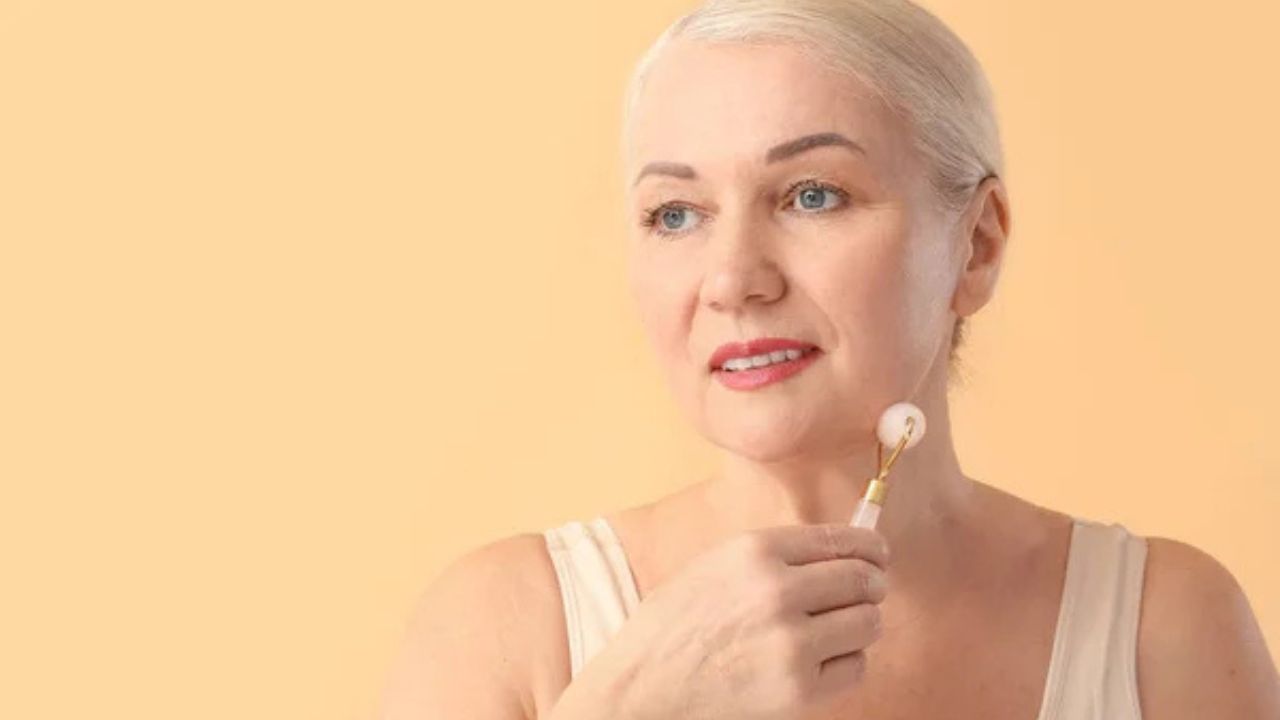 mulher madura fazendo massagem facial com equipamento